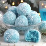 Beautiful blue Christmas truffles coated in sparkling sanding sugar on marble surface with holiday decorations - easy no-bake recipe
