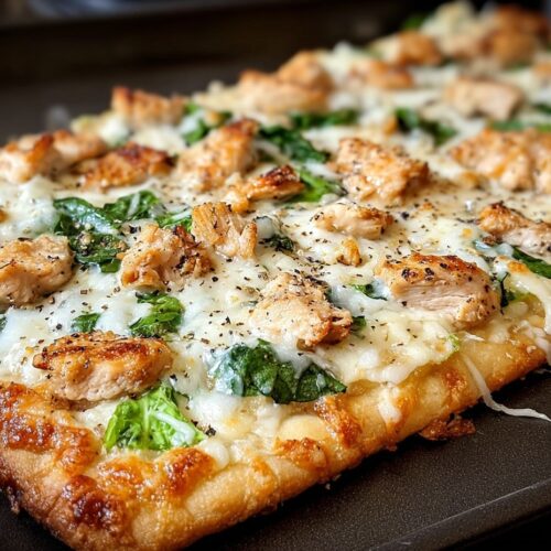 Golden chicken Caesar flatbread topped with grilled chicken, fresh romaine lettuce, Parmesan cheese and croutons on wooden cutting board