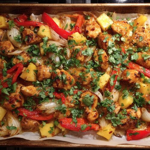 Golden Hawaiian chicken sheet pan with caramelized pineapple, colorful bell peppers, and tender chicken pieces fresh from the oven