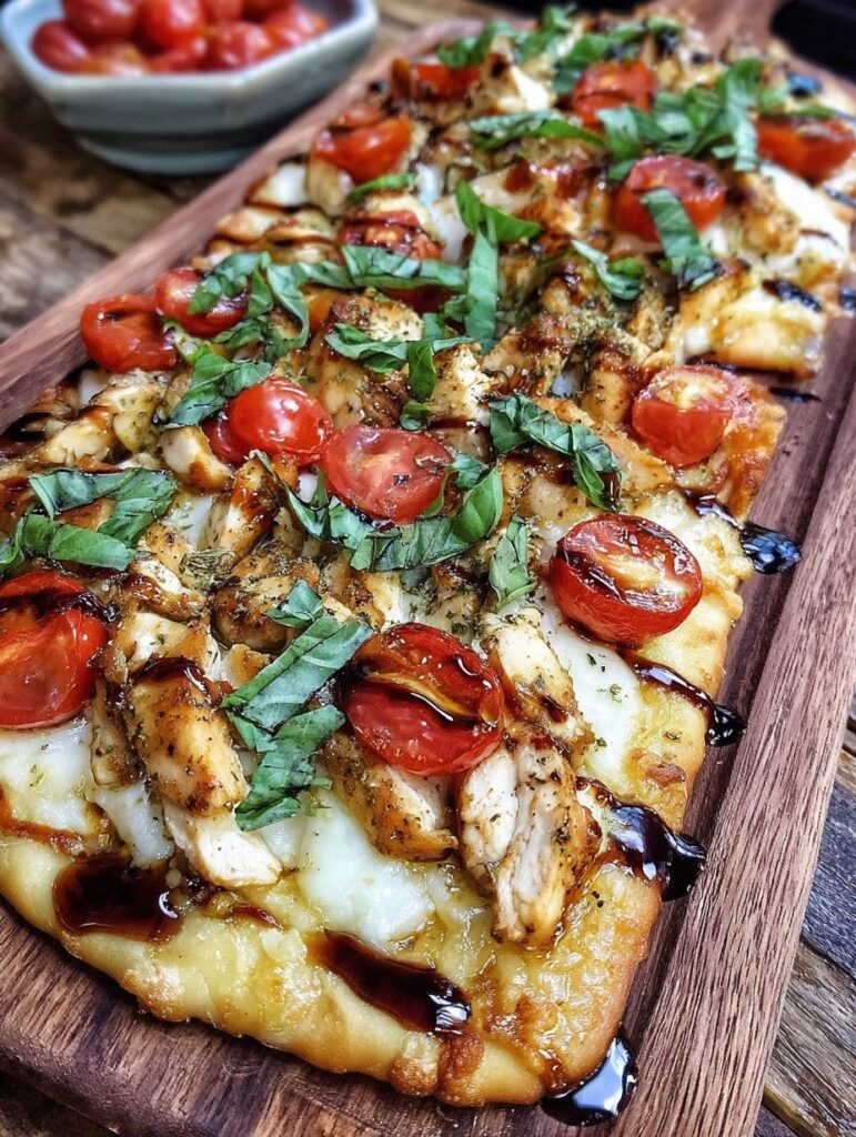 Chicken caprese flatbread with melted mozzarella, tomatoes, and fresh basil on crispy flatbread base